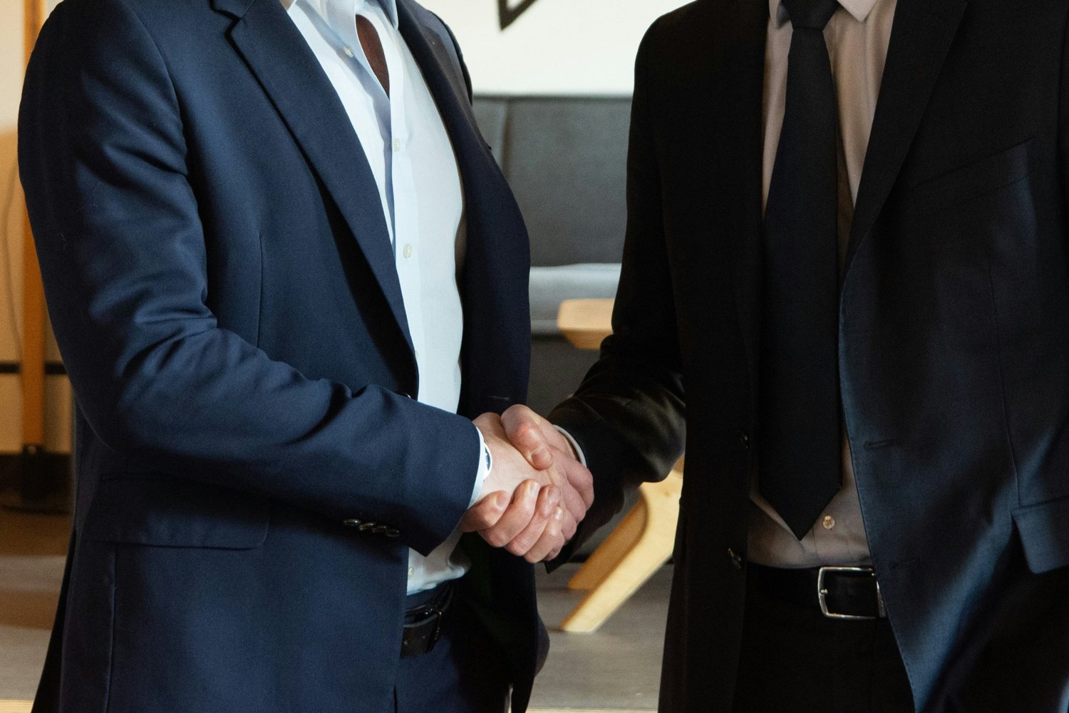 Two people in business suits shaking hands